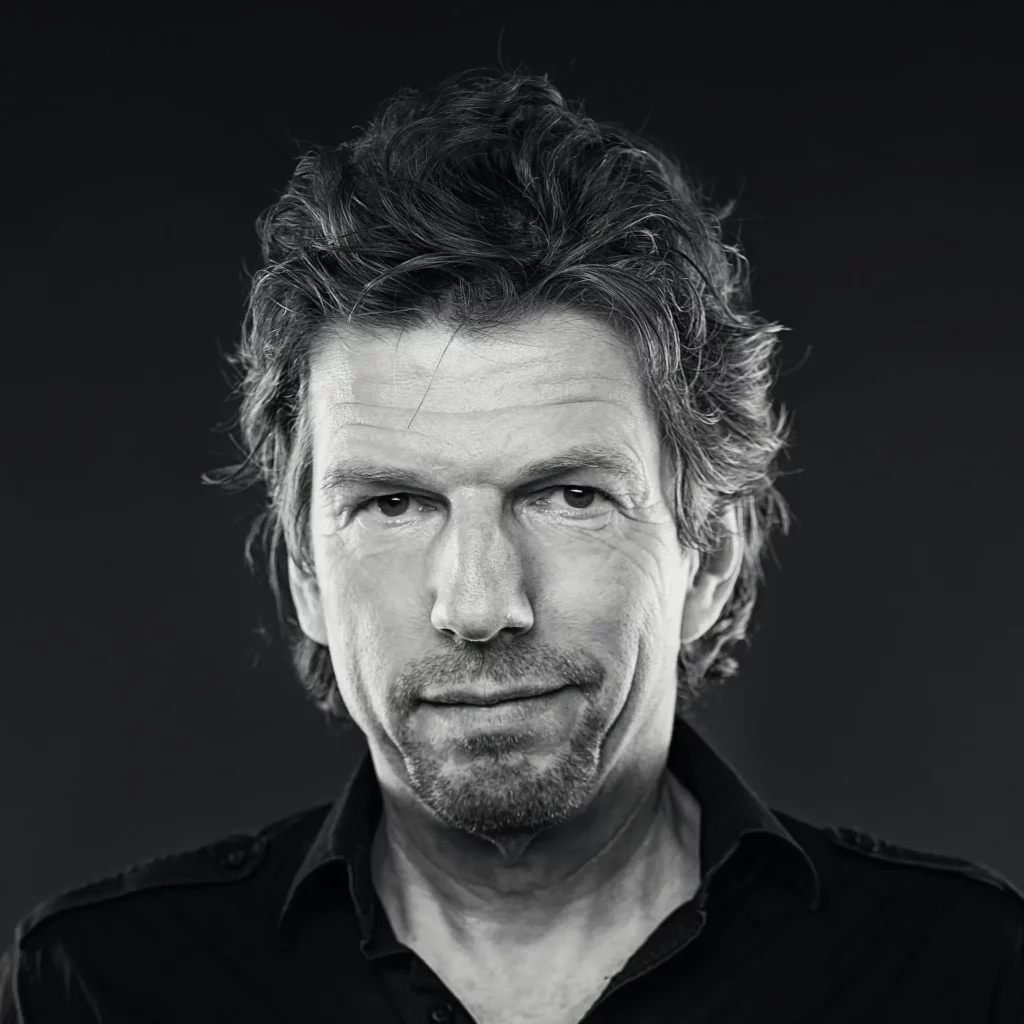 "Gründungsmitglied Rainer Schumann - Schwarz-Weiß-Foto, freundliches Lächeln, sympathisch.